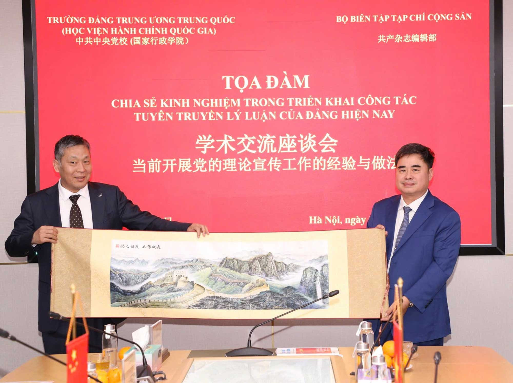 Đồng chí Đổng Chấn Hoa - Trưởng Ban Nghiên cứu và giảng dạy Chủ nghĩa xã hội khoa học, Trường Đảng Trung ương Đảng Cộng sản Trung Quốc trao quà lưu niệm tặng PGS, TS Phạm Minh Tuấn - Phó Tổng Biên tập Tạp chí Cộng sản_Ảnh: PV